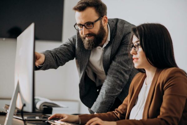 two business partners working together on the office computer